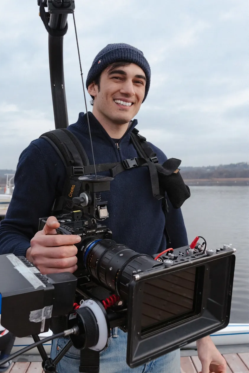 Giacomo Lommi sul set nel 2022, con la camera da cinema in mano, su un molo (foto in bianco e nero)